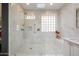 Spa-like bathroom featuring a large walk-in shower and marble tile at 21159 N Redington Point Dr, Surprise, AZ 85387