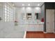 Elegant bathroom with double vanity, marble shower, and stone accent wall at 21159 N Redington Point Dr, Surprise, AZ 85387