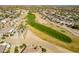 Aerial view of a golf course community with houses, palm trees, and a lake at 19661 N Echo Rim Dr, Surprise, AZ 85387