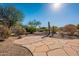 Landscaped backyard with flagstone patio and desert plants at 19661 N Echo Rim Dr, Surprise, AZ 85387