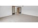 Open living room with neutral carpet and double doors leading to another room at 15234 N 19Th Pl, Phoenix, AZ 85022