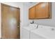 Laundry room with washer, dryer, and wood cabinets at 15234 N 19Th Pl, Phoenix, AZ 85022