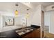 Kitchen with double sink, wood cabinets, and a view of the living room at 3313 N 68Th St # 203, Scottsdale, AZ 85251