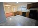 Kitchen with wood cabinets, black appliances, and tile floor at 7857 E Flossmoor Ave, Mesa, AZ 85208