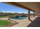 Relaxing covered patio overlooking a refreshing pool and waterfall feature at 7855 E Kramer St, Mesa, AZ 85207