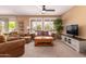 Comfortable living room featuring brown leather furniture and large windows at 16428 W Labyrinth Ln, Surprise, AZ 85374