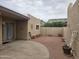 Private patio with brick and concrete flooring, potted plants, and a gate at 3345 E University Dr # 25, Mesa, AZ 85213