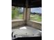 Relaxing bathroom with a corner jetted tub and large windows with golf course views at 21956 N 59Th Ln, Glendale, AZ 85310