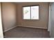 Simple carpeted bedroom with large window and double doors at 21956 N 59Th Ln, Glendale, AZ 85310