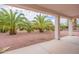 Landscaped backyard with palm trees and gravel at 13441 W El Sueno Ct, Sun City West, AZ 85375