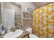 Clean bathroom with single sink, granite countertop, and yellow shower curtain at 6835 W Taylor St # 208, Phoenix, AZ 85043