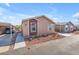 Tan and maroon manufactured home with carport and small landscaping at 6835 W Taylor St # 208, Phoenix, AZ 85043