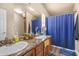 Bathroom with double sinks, granite countertop, and blue shower curtain at 6835 W Taylor St # 208, Phoenix, AZ 85043