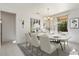 Virtually staged dining room with a large table and chandelier at 16121 W Silver Falls Dr, Surprise, AZ 85374