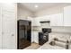 Modern kitchen with white cabinets, black appliances, and granite countertops at 915 E Agua Fria Ln, Avondale, AZ 85323