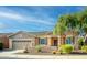 Tan house with a three-car garage, landscaping, and a blue sky at 42531 W Heavenly Pl, Maricopa, AZ 85138