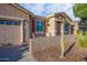 Front view of a tan house with a two-car garage and seating area at 42531 W Heavenly Pl, Maricopa, AZ 85138