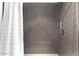 Clean shower with gray tile and white shower curtain at 73 W Lewis Ave, Phoenix, AZ 85003