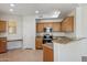 Kitchen with wood cabinets, granite countertops, and a breakfast bar at 14575 W Mountain View Blvd # 221, Surprise, AZ 85374