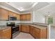 Kitchen with wood cabinets, granite counters, and stainless steel appliances at 14575 W Mountain View Blvd # 221, Surprise, AZ 85374