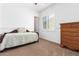 Well-lit bedroom with a daybed, dresser, and large window at 9845 E Inglewood St, Mesa, AZ 85207