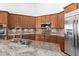 Granite kitchen island with double sink and stainless steel appliances at 9845 E Inglewood St, Mesa, AZ 85207
