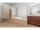 Spa-like bathroom with soaking tub and glass block shower at 9845 E Inglewood St, Mesa, AZ 85207