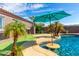 Inviting backyard oasis featuring a sparkling pool, waterfall, and putting green at 9845 E Inglewood St, Mesa, AZ 85207