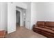 Relaxing bedroom with a leather couch and access to a full bathroom at 9845 E Inglewood St, Mesa, AZ 85207