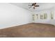 Spacious bedroom with carpeted floor, ceiling fan, and access to backyard at 9845 E Inglewood St, Mesa, AZ 85207