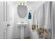 Small bathroom with pedestal sink, oval mirror, and decorative towels at 9845 E Inglewood St, Mesa, AZ 85207