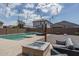 Relaxing backyard oasis with a sparkling pool, fire pit, and string lights at 20165 W Hadley St, Buckeye, AZ 85326