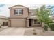 Two-story house with tan siding and a large garage at 20165 W Hadley St, Buckeye, AZ 85326