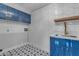 Laundry room with blue cabinets, white subway tile, and a stylish sink at 12222 N 74Th St, Scottsdale, AZ 85260