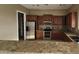 Kitchen with granite countertops and dark wood cabinets at 376 N Iron Horse Dr, Coolidge, AZ 85128