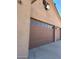 Three-car garage with brown doors and additional lighting at 376 N Iron Horse Dr, Coolidge, AZ 85128