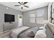 Main bedroom with private door to outdoor space, ceiling fan, and large TV at 20100 N 78Th Pl # 2179, Scottsdale, AZ 85255