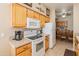 Modern kitchen with wood cabinets, white appliances, and a breakfast nook at 14950 W Mountain View Blvd # 1203, Surprise, AZ 85374