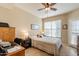 Spacious bedroom with a ceiling fan, large window, and private access to balcony at 14950 W Mountain View Blvd # 1203, Surprise, AZ 85374
