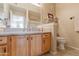 Clean bathroom with wood vanity, large mirror, and a toilet at 14950 W Mountain View Blvd # 1203, Surprise, AZ 85374