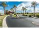 Gated community entrance with palm trees and landscaping at 42988 W Misty Morning Ln, Maricopa, AZ 85138