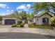 Elegant two-story home with a gray garage door and lush landscaping at 7661 E Solano Dr, Scottsdale, AZ 85250