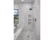 Spacious shower with marble tile, built-in shelves, and glass enclosure at 7661 E Solano Dr, Scottsdale, AZ 85250