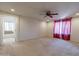Spacious bedroom with ceiling fan and red curtains at 11040 E Tumbleweed Ave, Mesa, AZ 85212