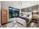 Spacious bedroom with a large window, hardwood floors, and a ceiling fan at 7175 E Camelback Rd # 107, Scottsdale, AZ 85251
