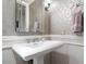 Stylish powder room with patterned wallpaper and a pedestal sink at 7175 E Camelback Rd # 107, Scottsdale, AZ 85251