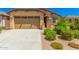 Tan house with a two-car garage and landscaping at 5837 N 89Th Dr, Glendale, AZ 85305