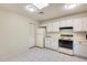 Efficient kitchen with white cabinets, appliances, and tile floor at 14300 W Bell Rd # 35, Surprise, AZ 85374