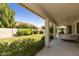 Covered patio overlooking a spacious backyard with lush landscaping at 9848 E Sunburst Dr, Sun Lakes, AZ 85248