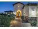 Elegant entryway with arched walkway, stone accents, and landscape lighting at 36495 N Livorno Way, Scottsdale, AZ 85262